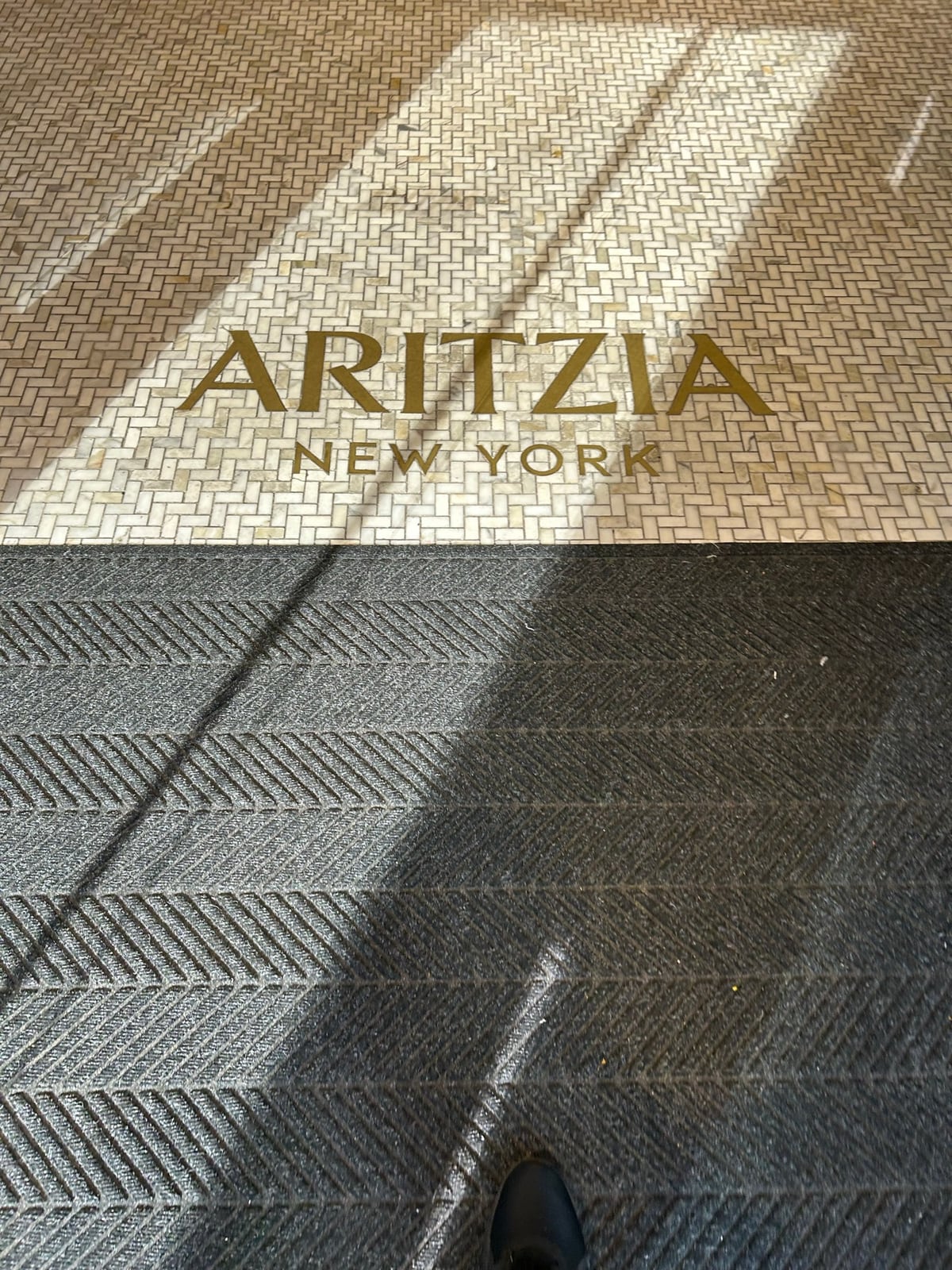 Aritzia New Yorkと書かれた店内入口付近の床ロゴ