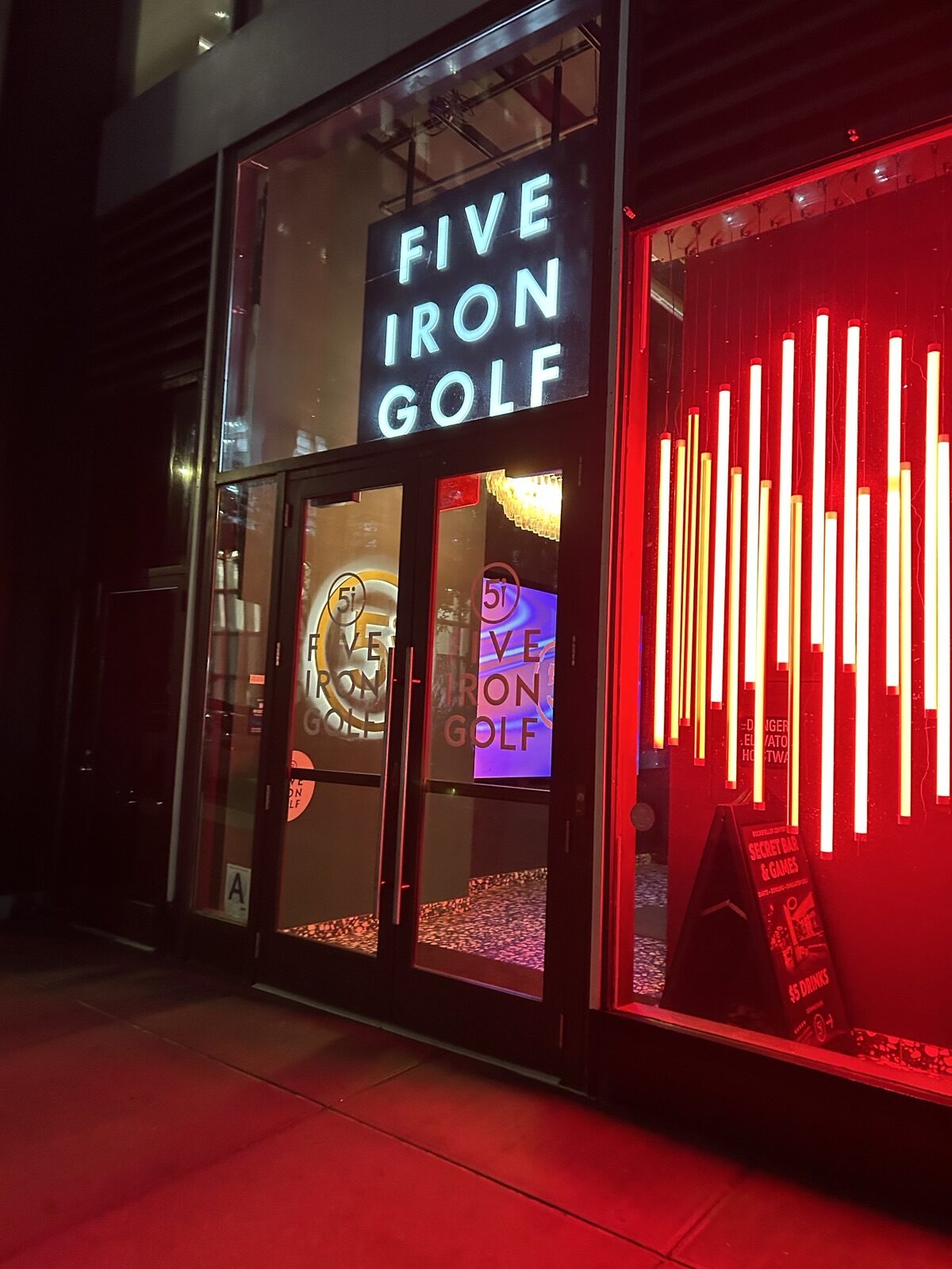 Five Iron Golf Rockefeller Centerの赤いネオンが光る入口