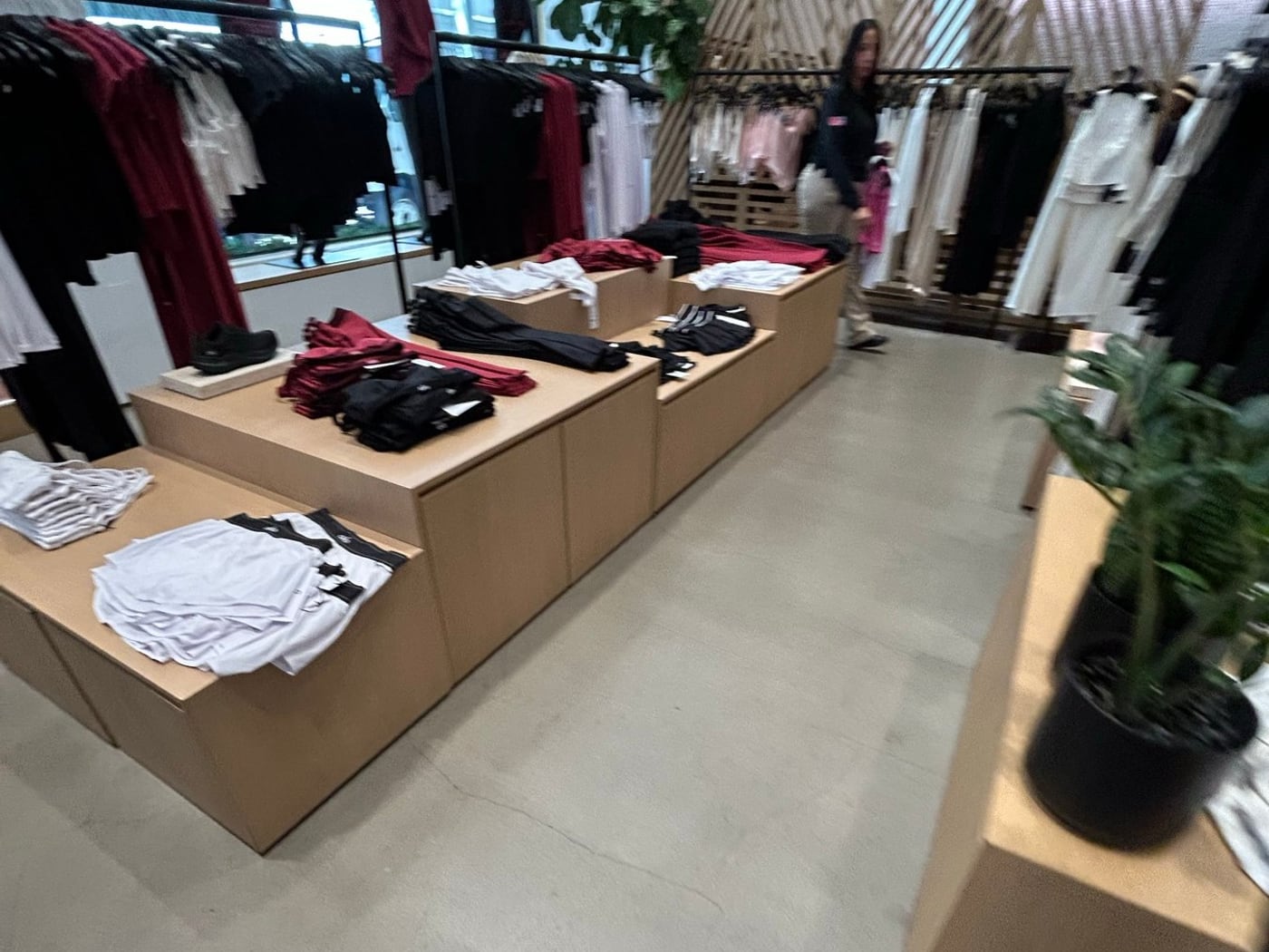 ALO Yoga店内の畳まれたウェアと商品テーブル