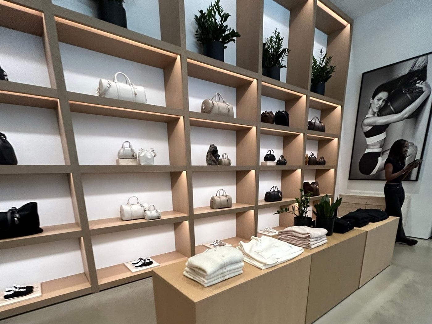 ALO Yoga店内の棚に並ぶレザー系バッグと白い服