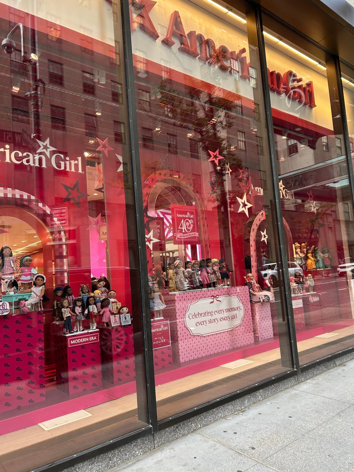 American Girl New Yorkのピンク色のウィンドウディスプレイと人形