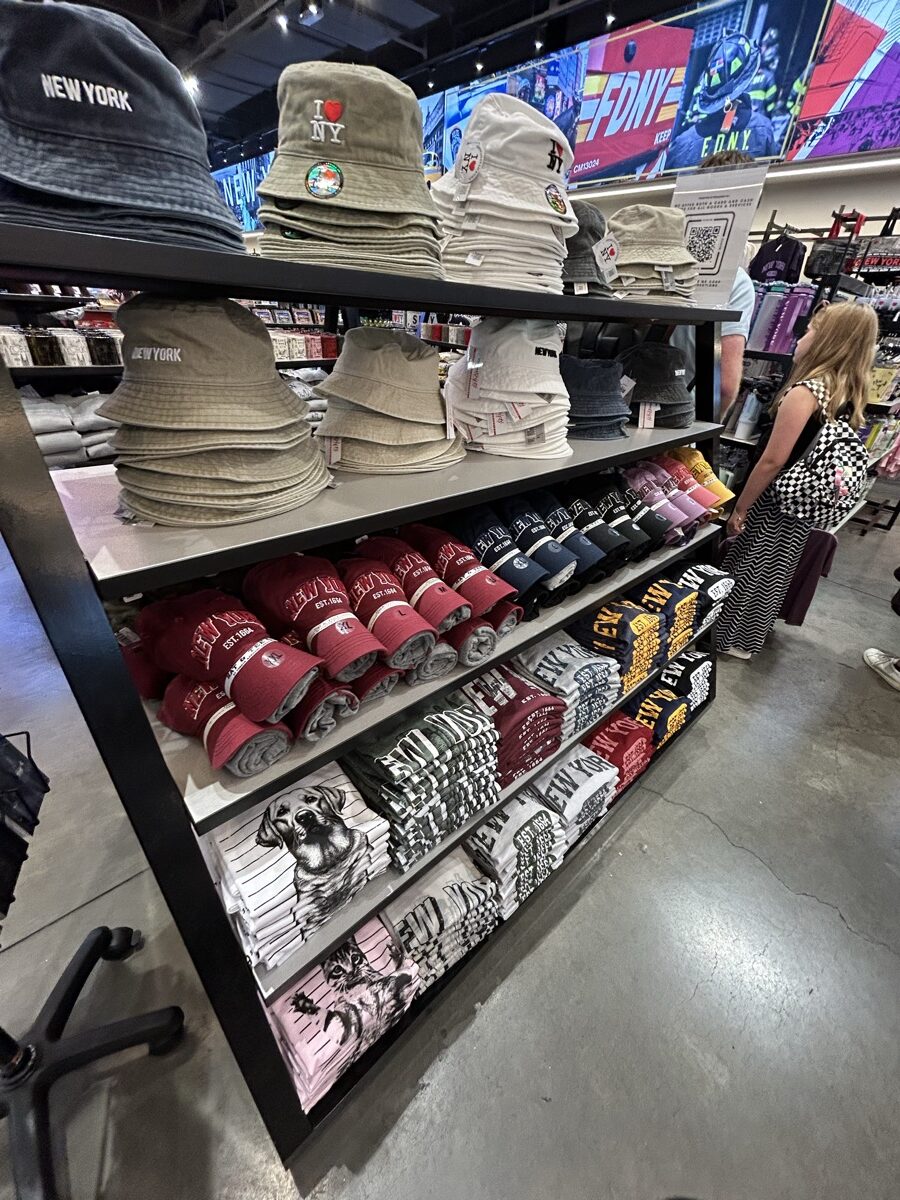 New Yorkロゴ入り帽子とTシャツが並ぶI Love NY Gifts店内