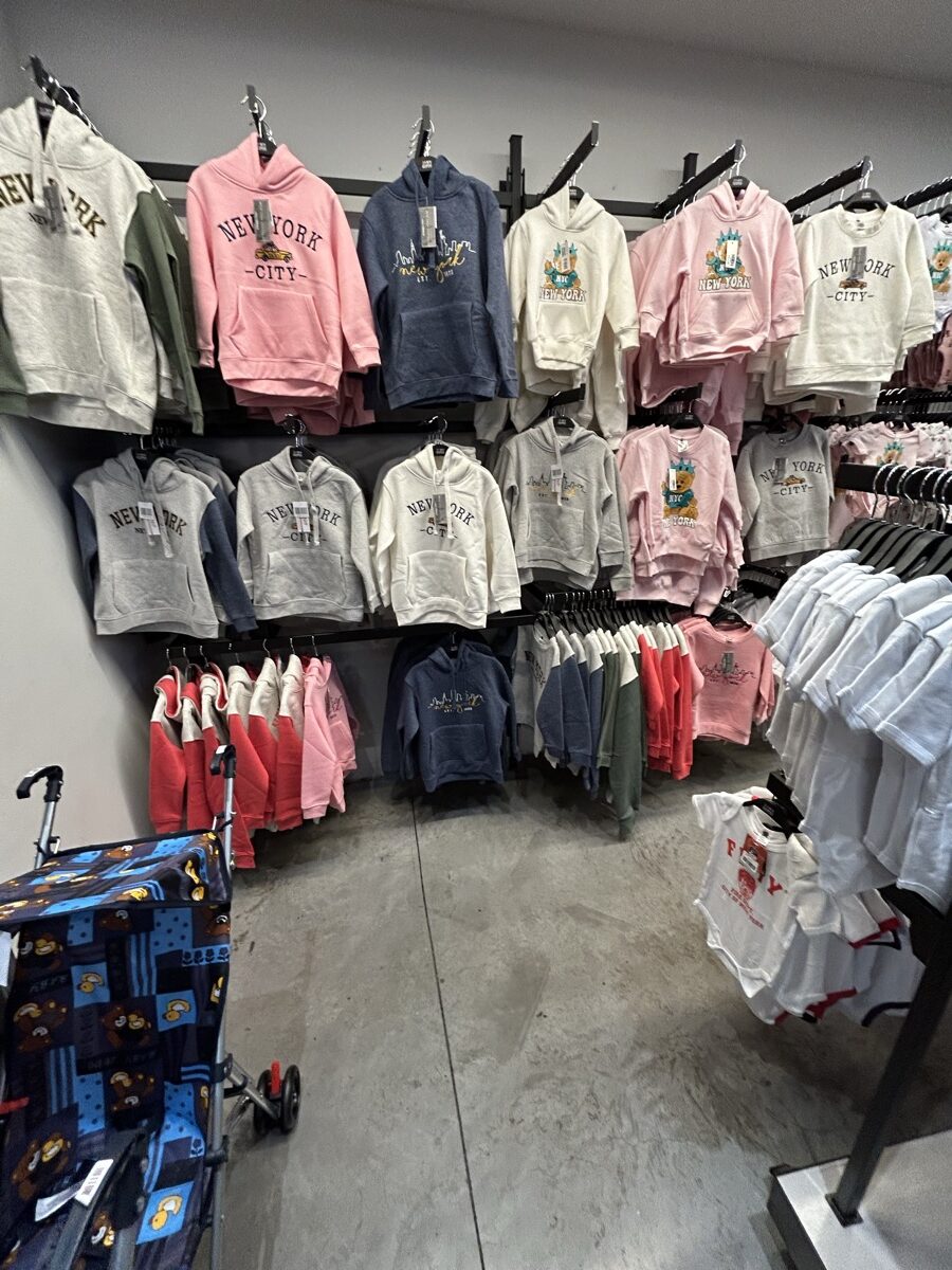 店の奥に大量に並ぶ子ども用New York CityパーカーやTシャツ
