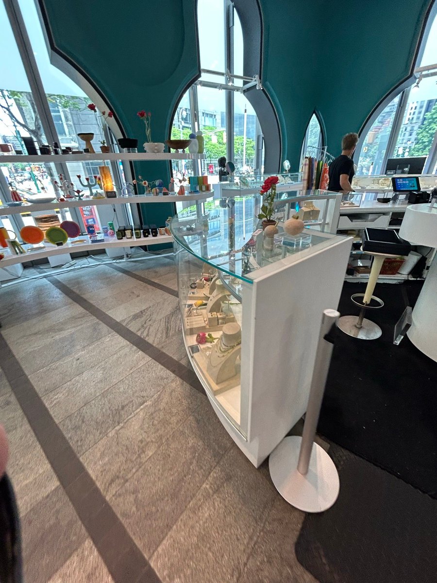 大きな窓と白い商品台があるThe Store at MADの店内