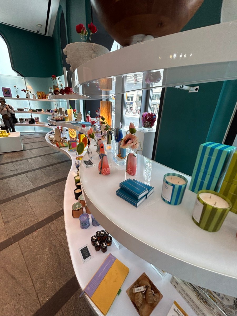 The Store at MADの白いカーブ棚に並ぶカラフルな器や雑貨