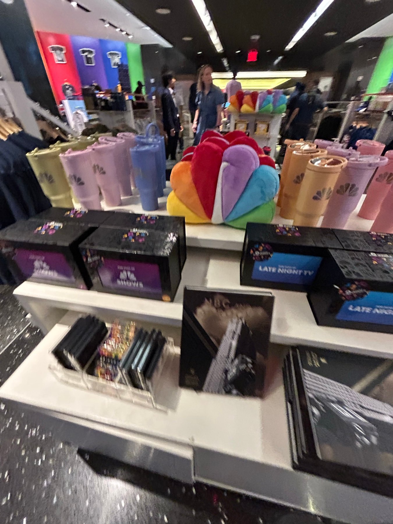 TODAY番組ロゴ入りグッズとNBCピーコックカラーの小物が並ぶ棚