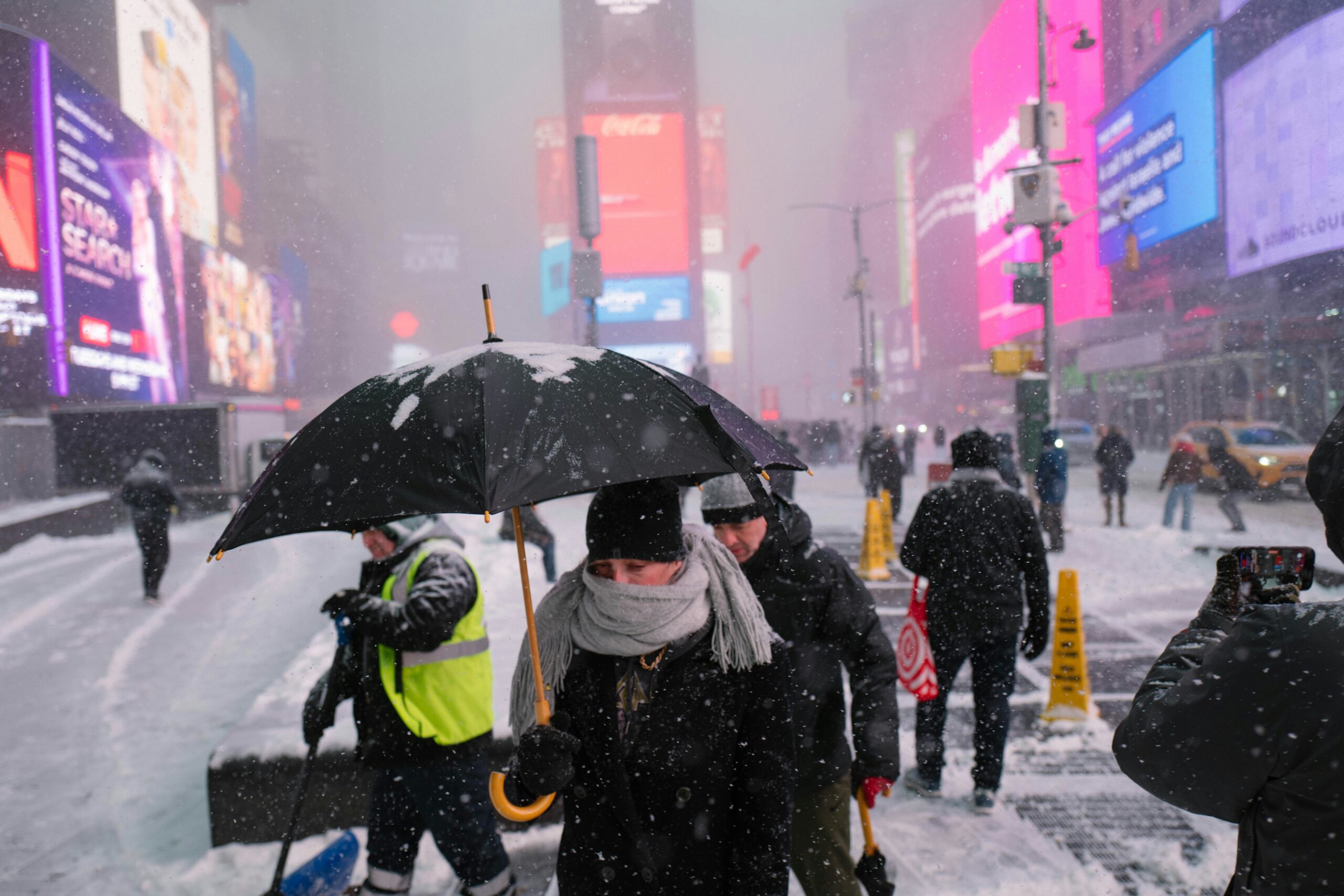 雪が降るニューヨークの街を歩く人たち